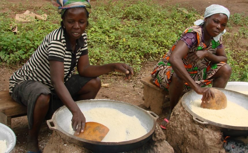 Das Bild zeigt zwei Frauen aus Kpassa, die Maniok zu Mehl verarbeiten