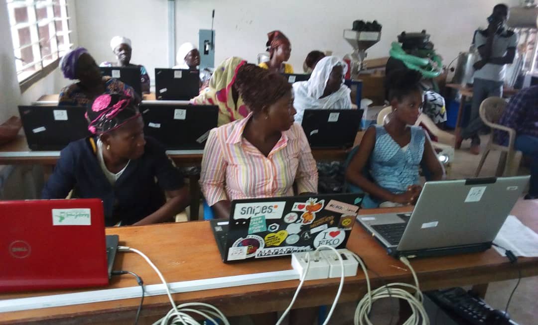 Female farmers are sitting in a computer lab and learning how to use a computer